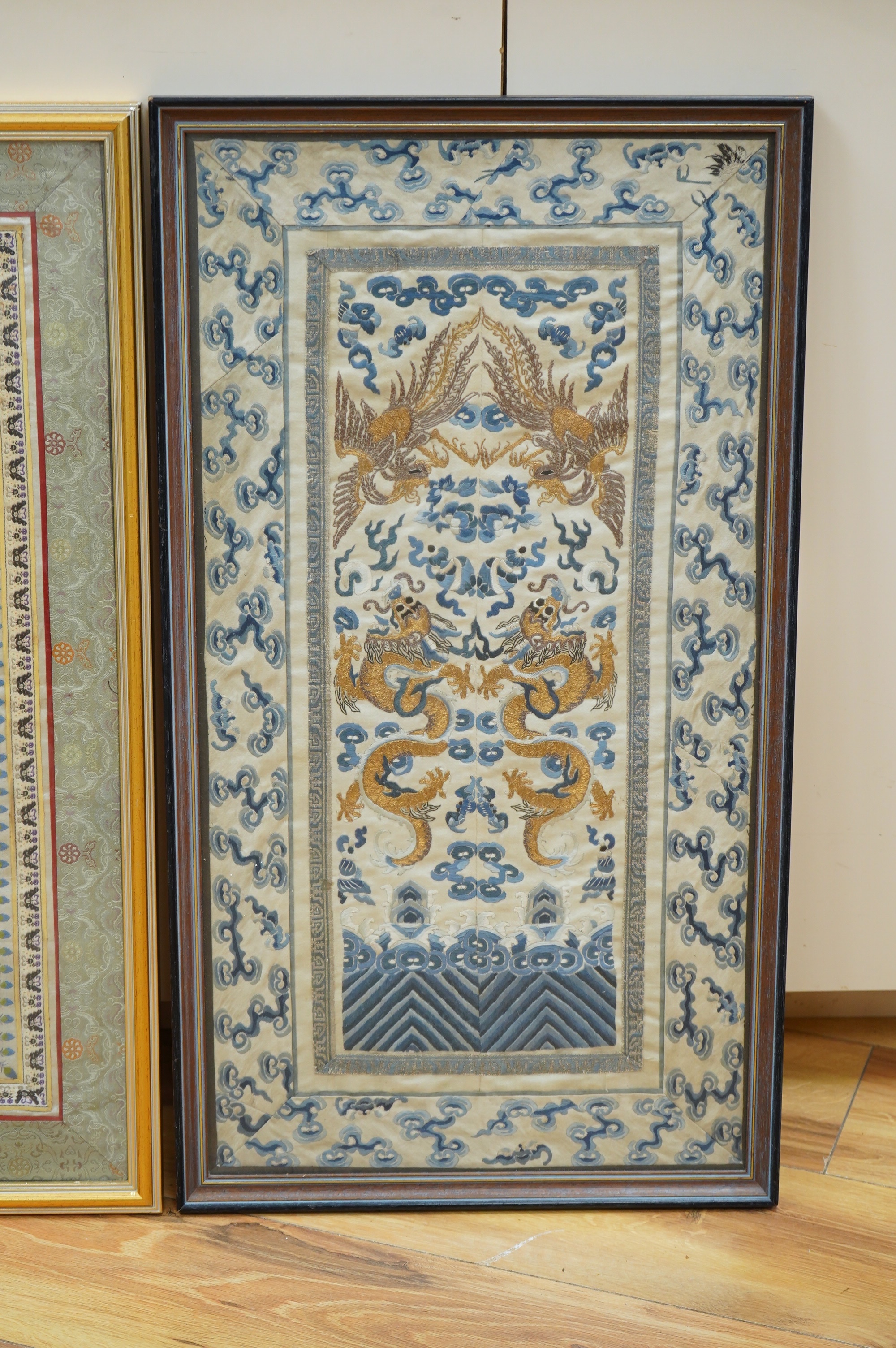 Two framed pairs of early 20th century Chinese silk embroidered sleeve bands; one pair embroidered in blue with Chinese knot as ornate bat motifs surrounded by floral motifs, edged in fine braiding and a black satin, sil